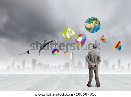 Back view of confident businessman looking at items flying in air. Elements of this image are furnished by NASA