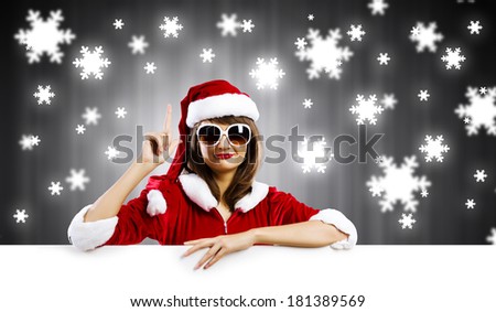 Girl in Santa costume with white blank banner. Place for text