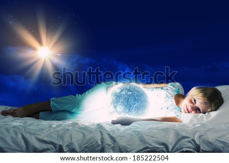 Girl lying in bed with moon in hands