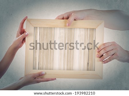 Close up of hands holding wooden blank frame. Place for text