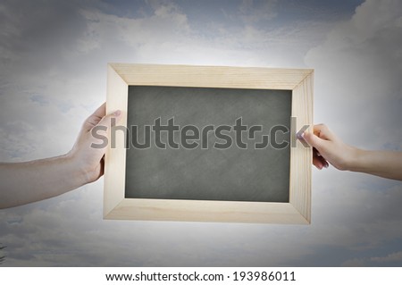 Close up of hands holding blank chalkboard