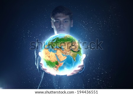 Young businessman holding Earth planet in hand. Elements of this image are furnished by NASA