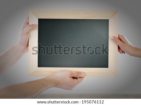 Close up of hands holding blank chalkboard