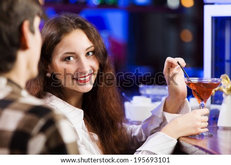 Young couple in bar having drinks and talking