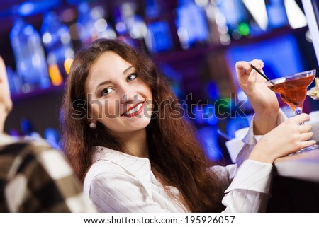 Young couple in bar having drinks and talking