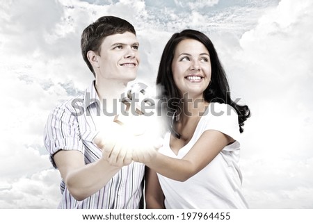 Young happy couple holding pound sign in palms