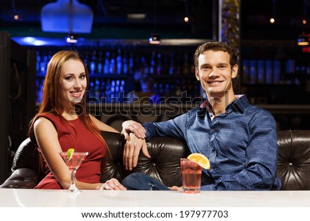 Young handsome man in bar accompanied by elegant lady