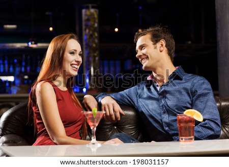Young handsome man in bar accompanied by elegant lady