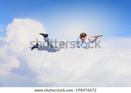 Young businessman flying in sky and lokking in spyglass