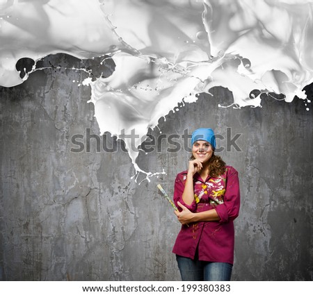 Young woman painter with brush and white splashes above