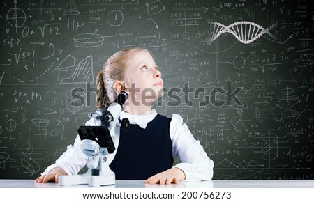 Cute school girl with microscope against blackboard with formulas