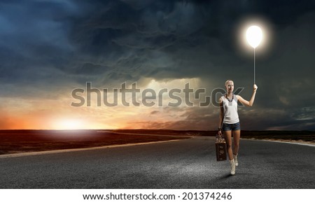 Young woman hiker walking with suitcase in hand