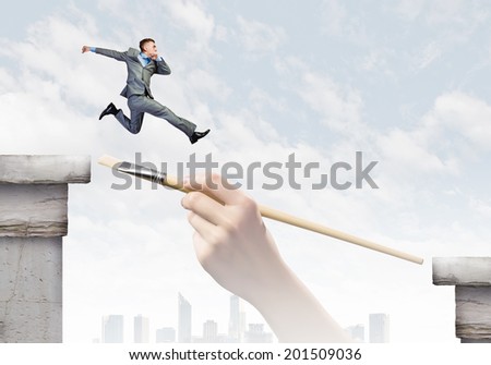 Young successful businessman jumping over gap. Risk and challenge concept