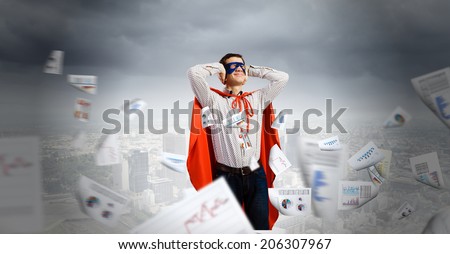 Young man in hero costume closing ears with palms