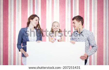 Young happy family with white blank banner. Place for text