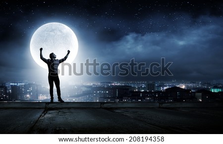 Young man at night with big full moon at background