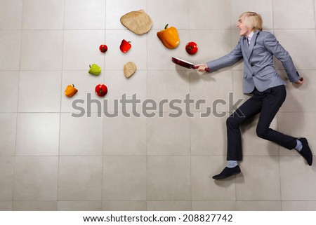 Young funny businessman running with pan in hand