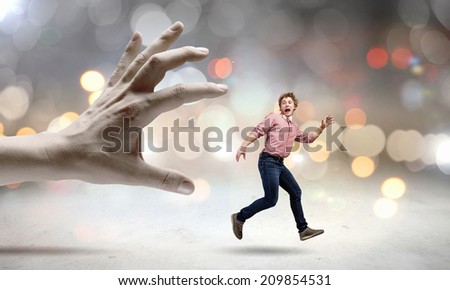 Young man trying to run away from big male hand