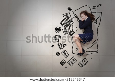 Tired businesswoman sleeping on floor and dreaming