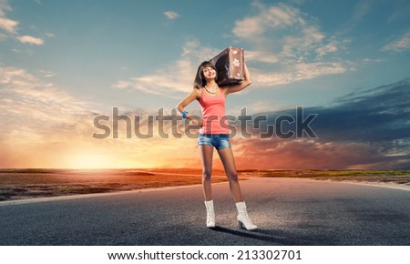 Young pretty woman tourist with suitcase with suitcase on shoulder