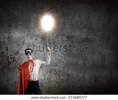 Young confident superman in mask and cape