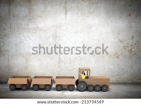 Young woman riding carton train. Women in business