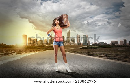 Young pretty woman tourist with suitcase with suitcase on shoulder