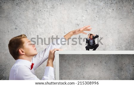 Angry businessman screaming at miniature of man colleague