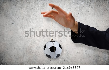 Close up of businessman hand and ball hanging on rope