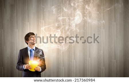 Young businessman holding yellow small bucket in hand