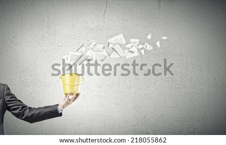 Close up of businessman holding yellow bucket in hand