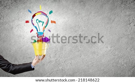 Close up of businessman hand holding bucket with paint