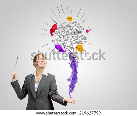 Young attractive businesswoman with paint brush and colorful business sketches