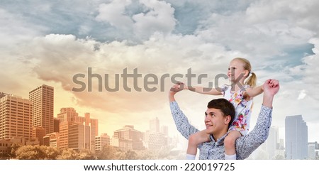 Happy daughter sitting on shoulders of her father