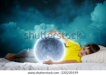Cute boy lying in bed and dreaming about moon