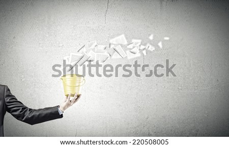 Close up of businessman holding yellow bucket in hand