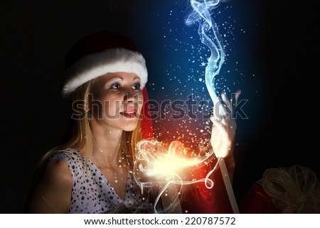 Happy woman in santa hat opening Christmas gift box