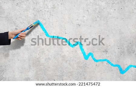 Close up of business person hand drawing graph on wall
