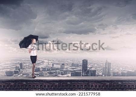 Young business lady on top of building with umbrella