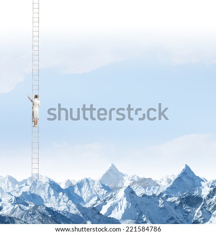 Businesswoman standing on ladder high above mountains