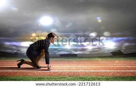 Side view of businesswoman at stadium standing in start position