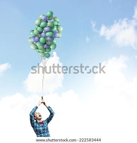 Young woman in casual holding bunch of colorful balloons