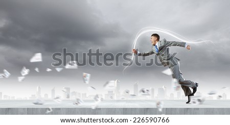 Young running businessman with colorful splashes in hand