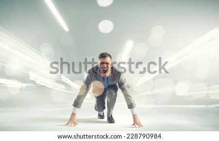Young businessman standing in start pose ready to run