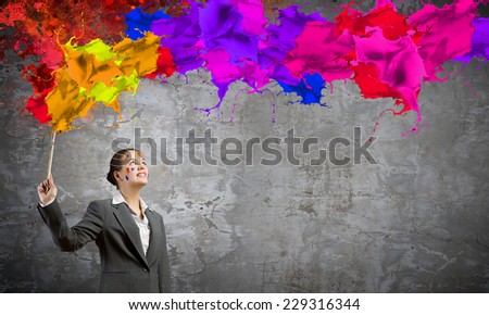 Young attractive businesswoman with paint brush in hand