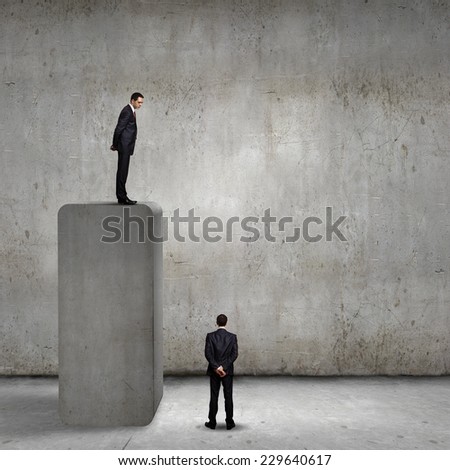 Businessman standing on bar and looking down at colleague