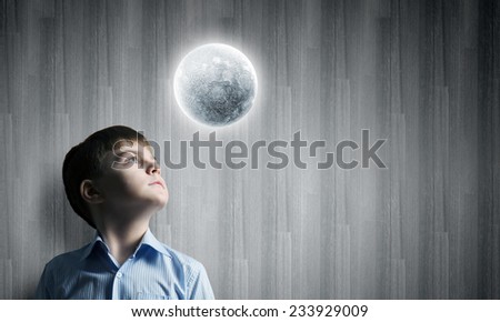 Cute boy of school age looking at moon