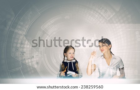 Young teacher and her pupil at lesson looking at media screen