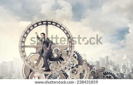 Young businessman in suit running in hamster wheel