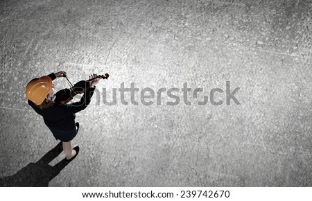 Top view of businesswoman in helmet playing violin